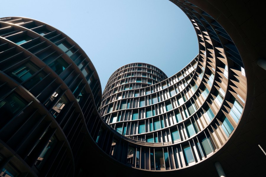 Looking up from the courtyard of Axel Towers in Copenhagen, two curved glass facades spiralling around an open wedge of sky.